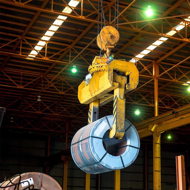 An overhead crane – Coil tong carrying a steel coil to a designat An overhead crane - Coil tong carrying a steel coil to a designat