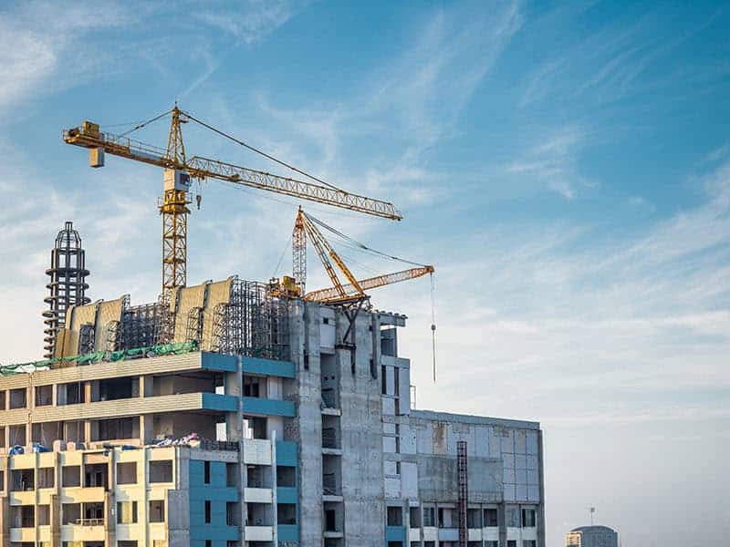 Modern building under construction Modern building condominium under crane construction against blue sky - Bangkok Thailand